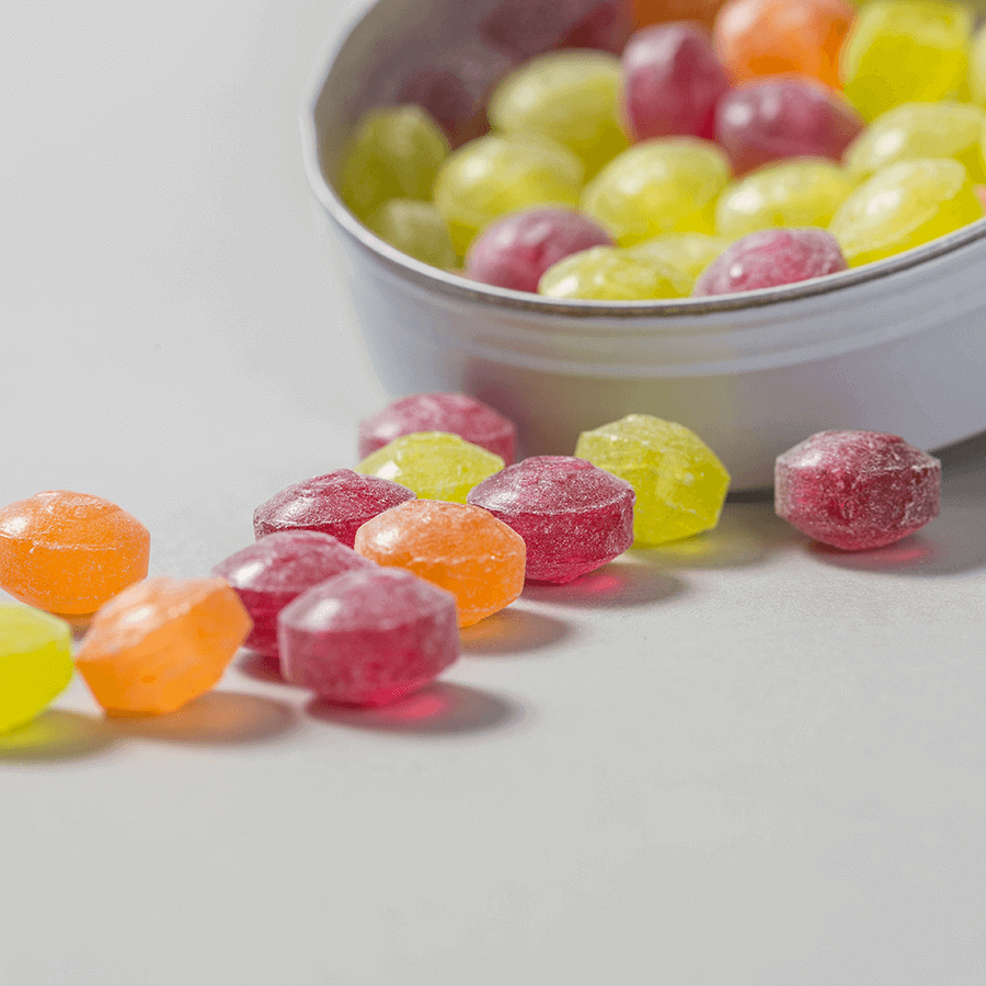 Geöffnete, runde Fruchtdose mit Pulmoll-Fruchtbonbons in verschiedenen Geschmacksrichtungen